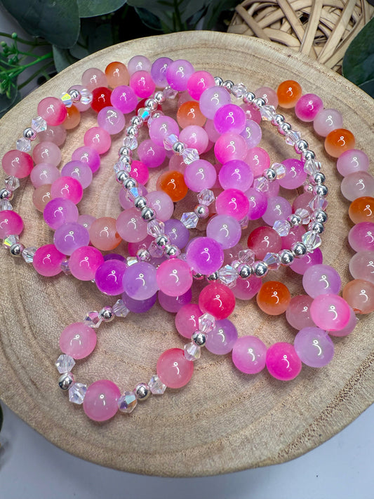 a collection of colorful beaded bracelets and necklaces arranged on a wooden surface.