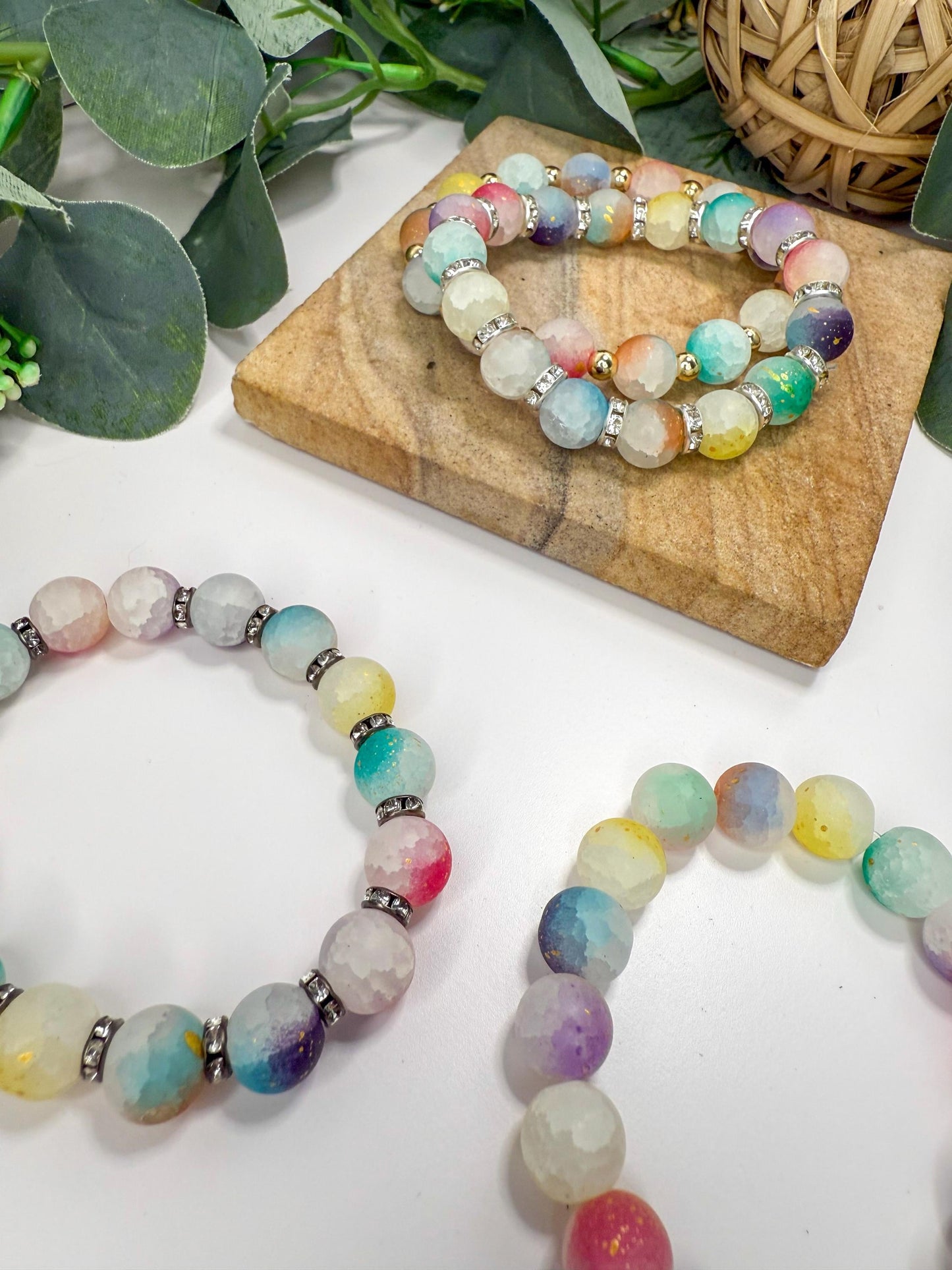 three colorful beaded bracelets arranged on a wooden surface. The bracelets have multicolored beads and metal accents, creating a vibrant and eye-catching display.