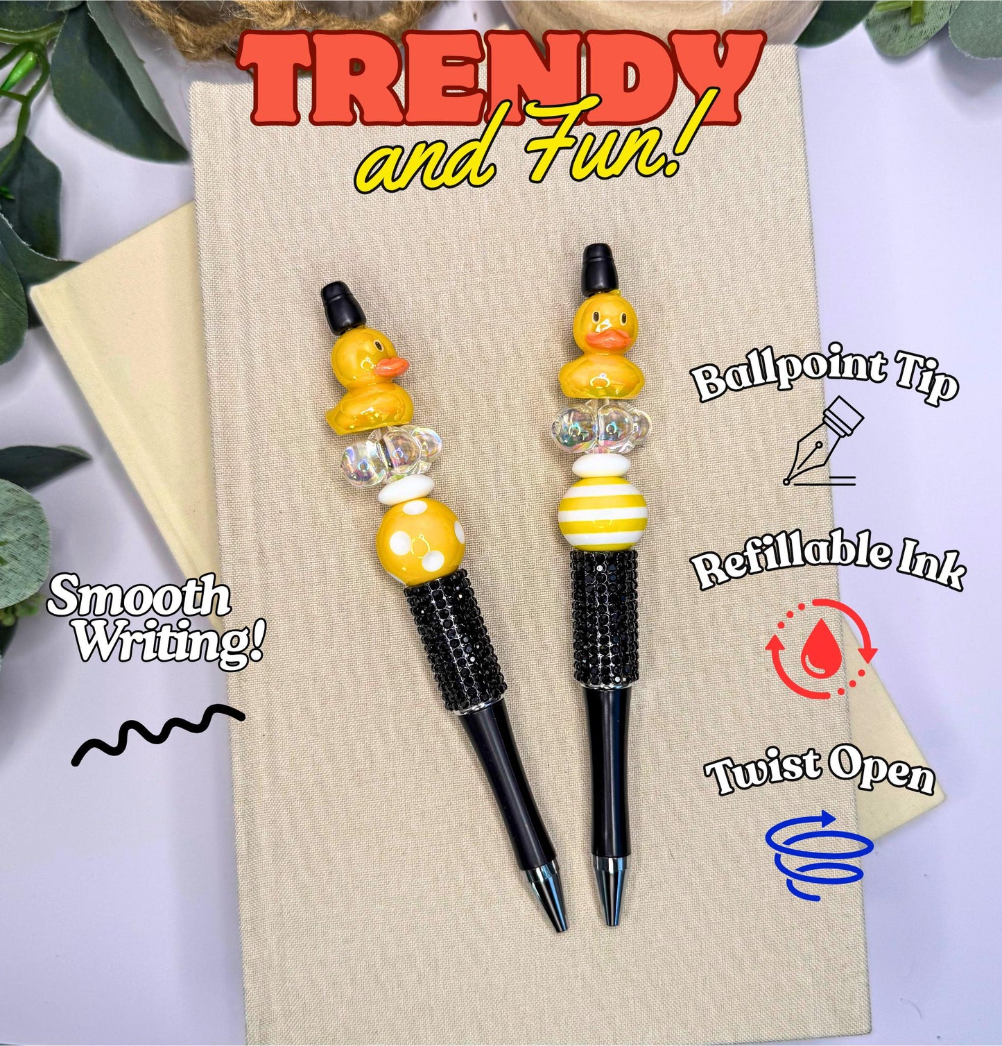 two yellow rubber duckie-themed pens with black and gold accents, placed on a beige surface.